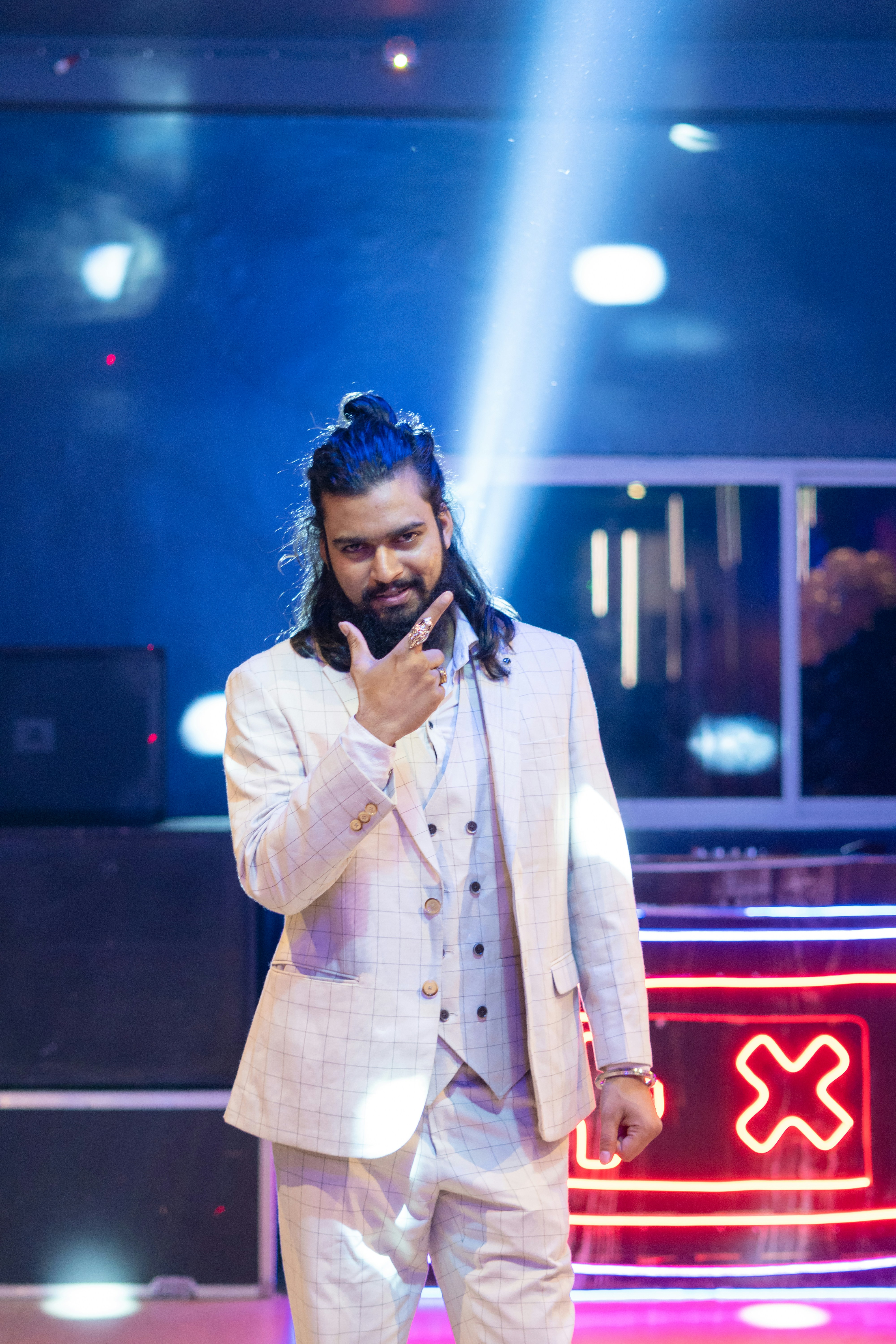 Un homme en costume blanc debout sur une scène