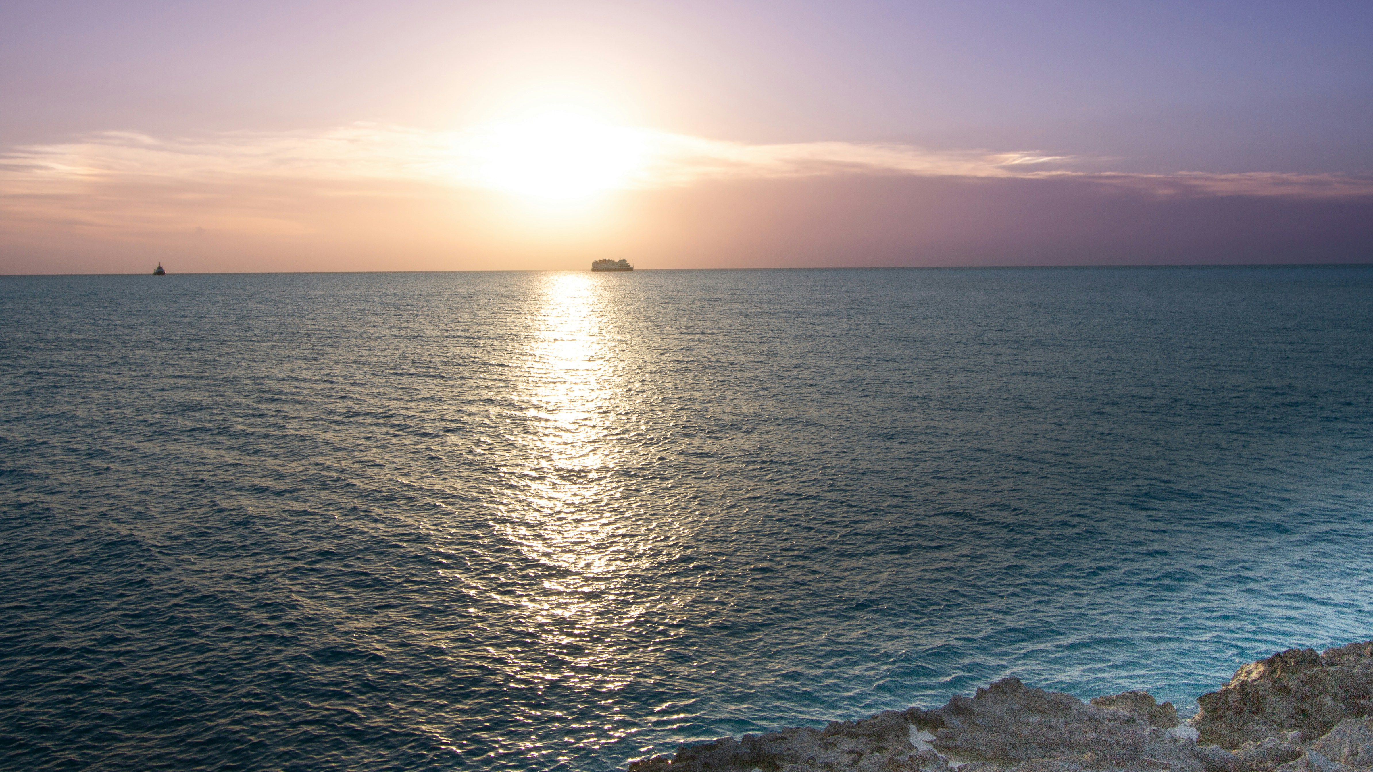The sun is setting over the ocean on a clear day