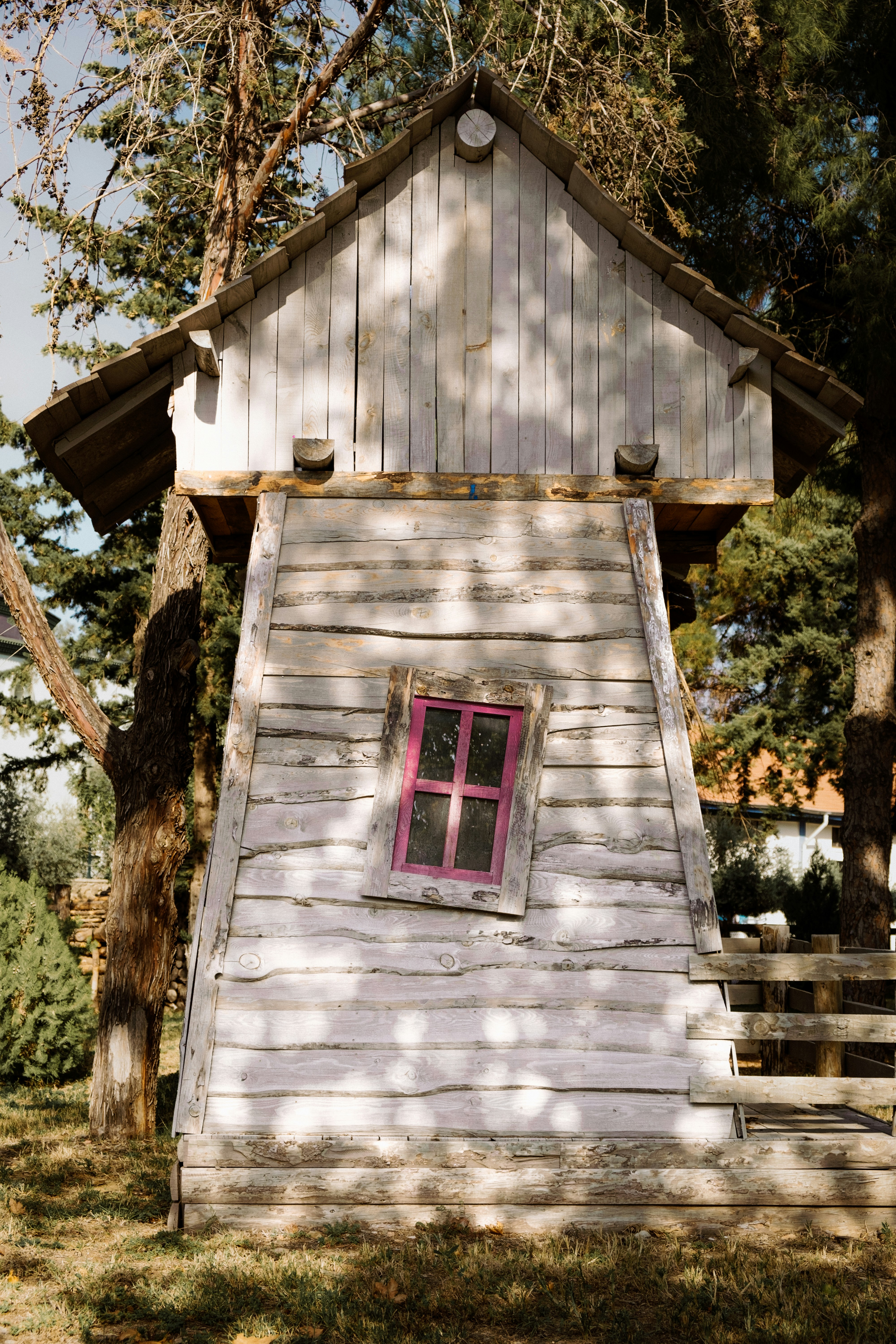 A small white building with a pink window