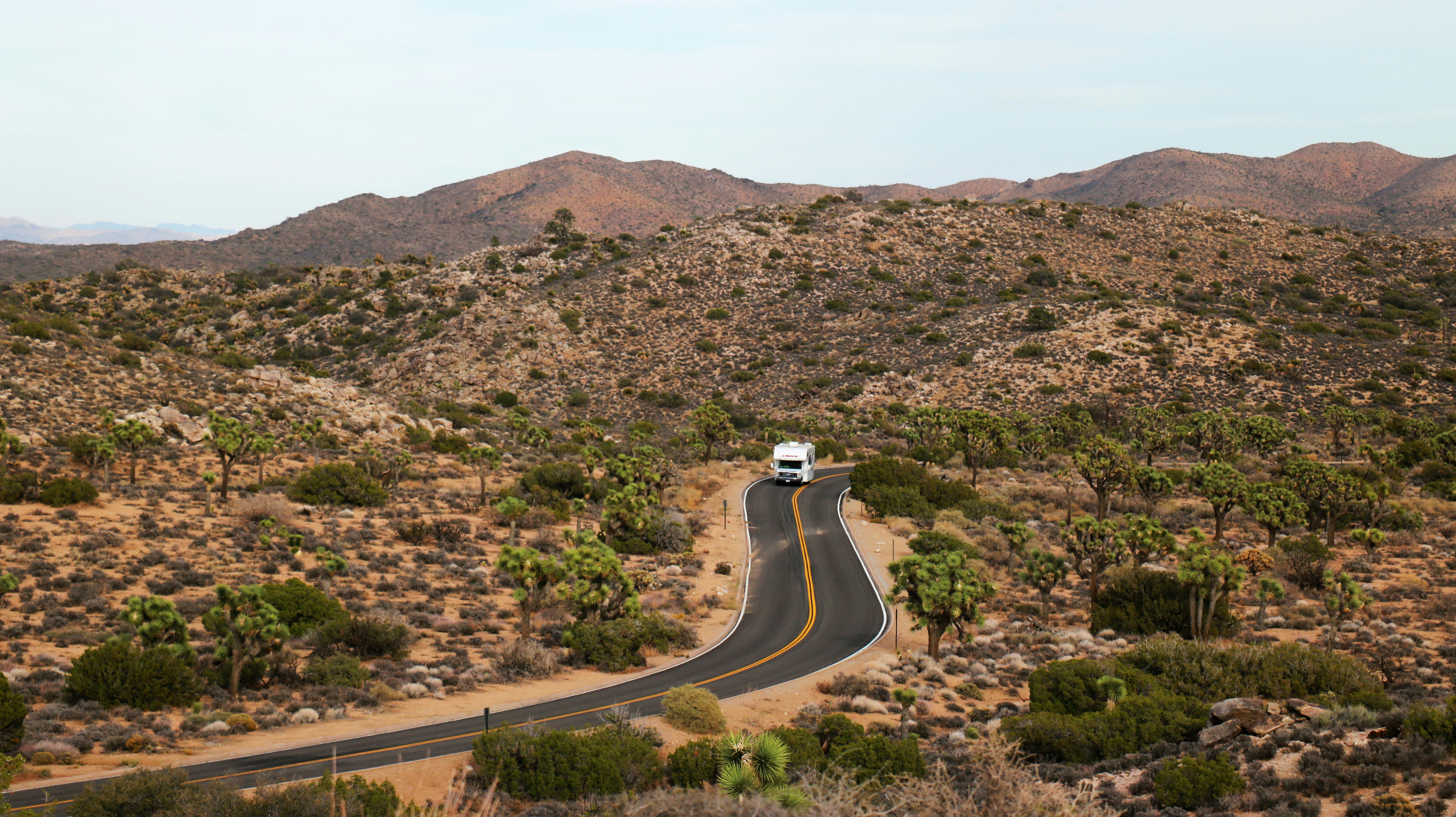 A truck driving down a road in the middle of a desert