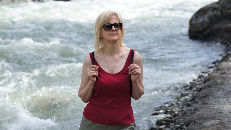 sugar mummy en débardeur rouge au bord de l'eau