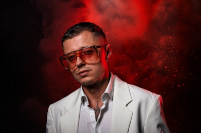 A man in a white suit and red glasses