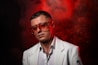 A man in a white suit and red glasses