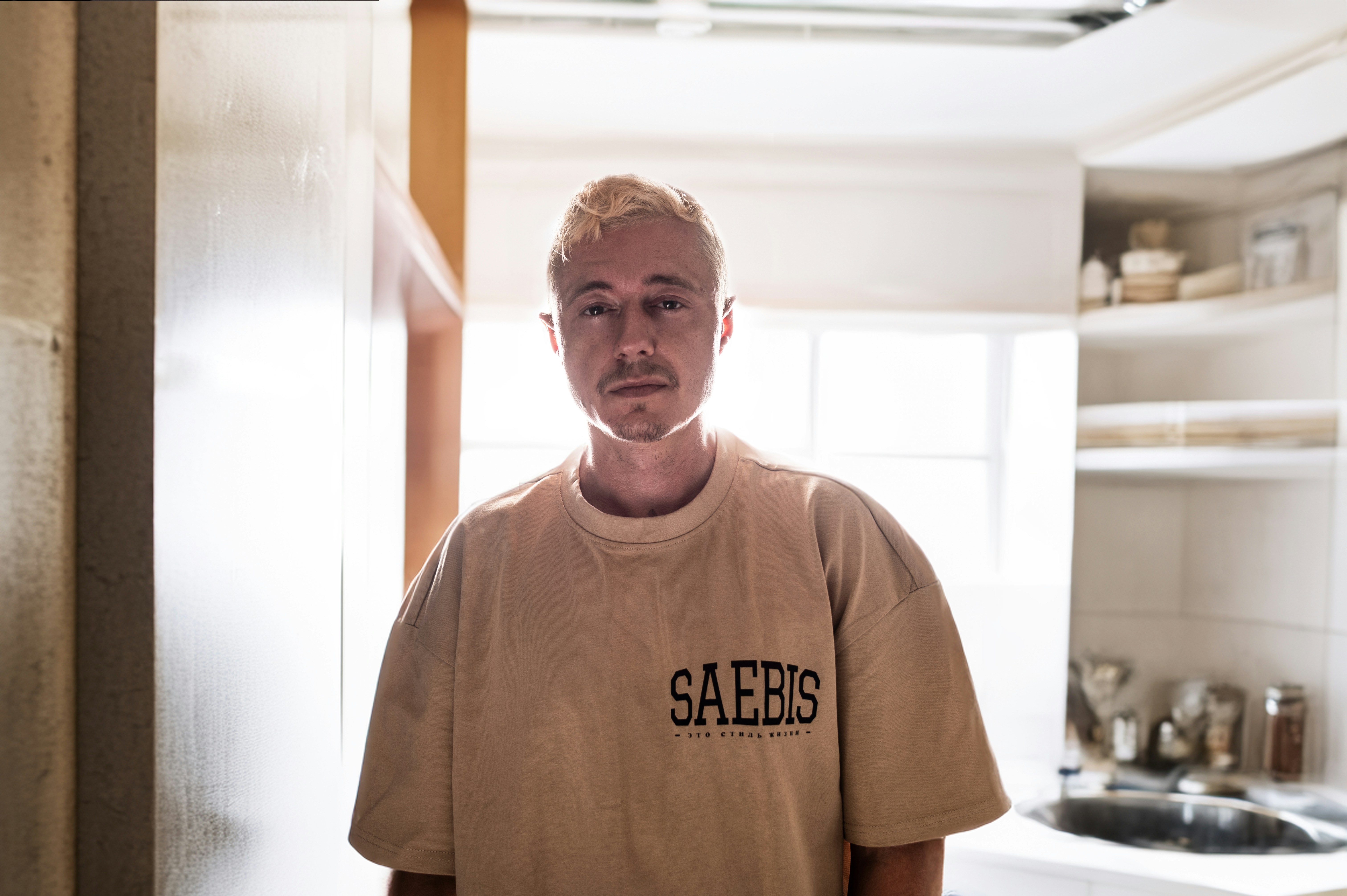 A man standing in a kitchen next to a sink (Photo by ELLA DON on Unsplash)