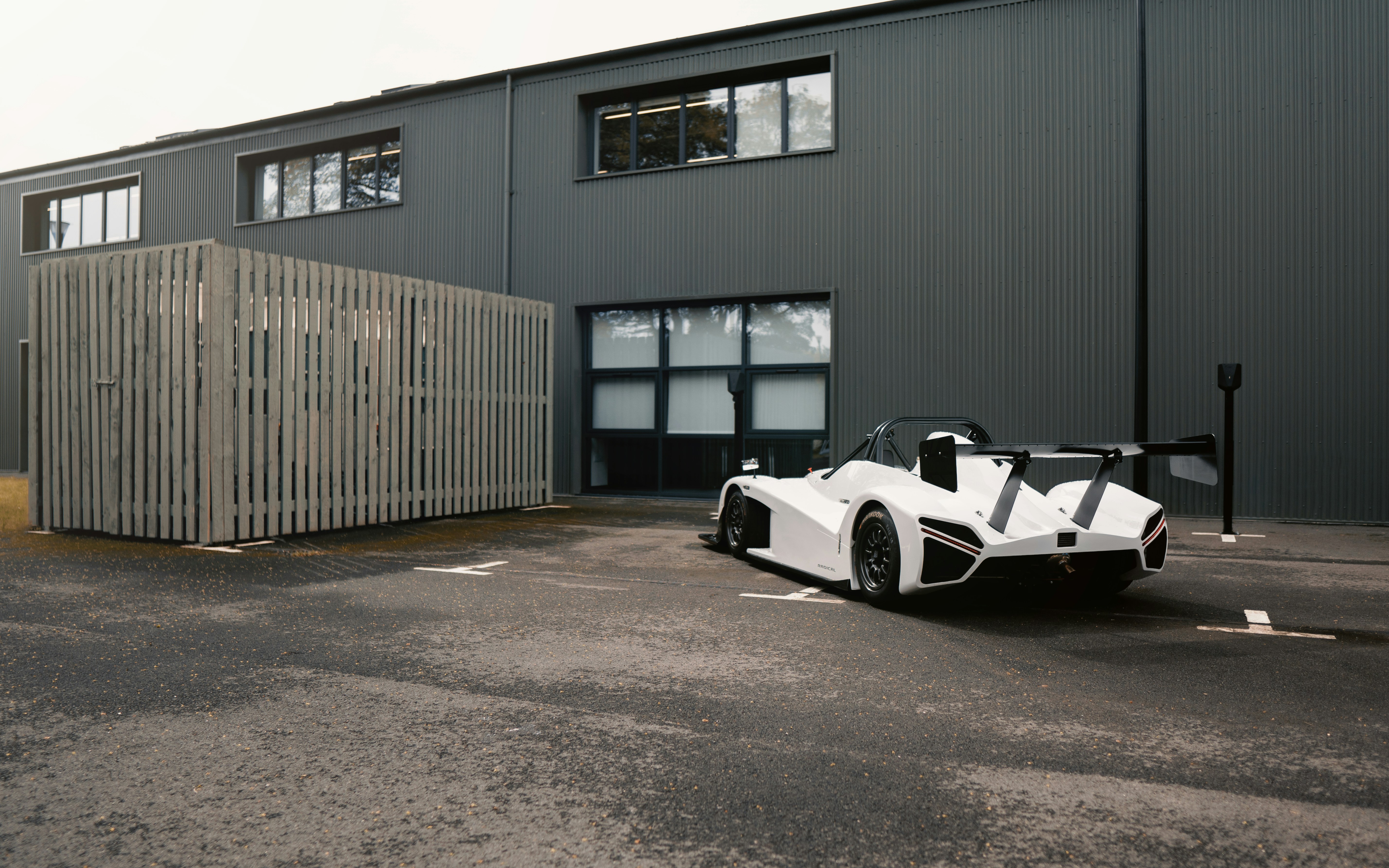 A white sports car parked in front of a building