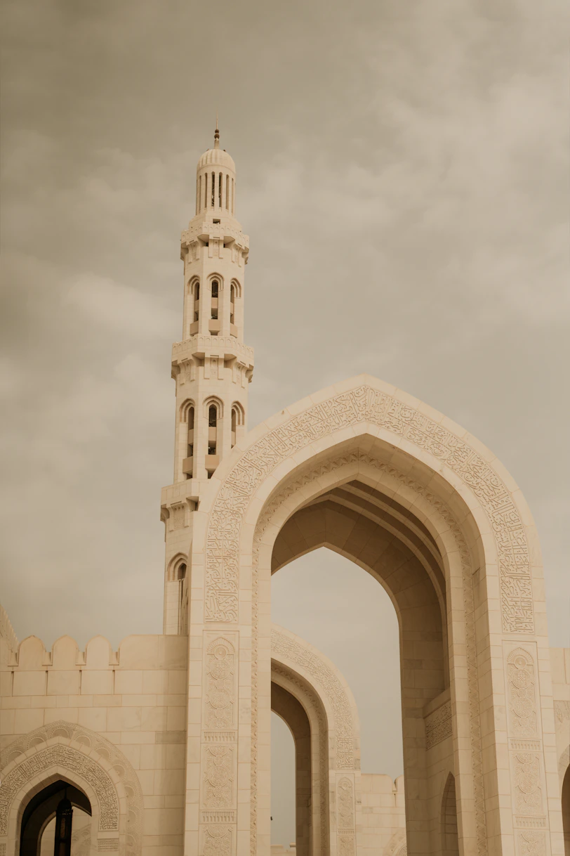 A tall white building with a clock tower in the background