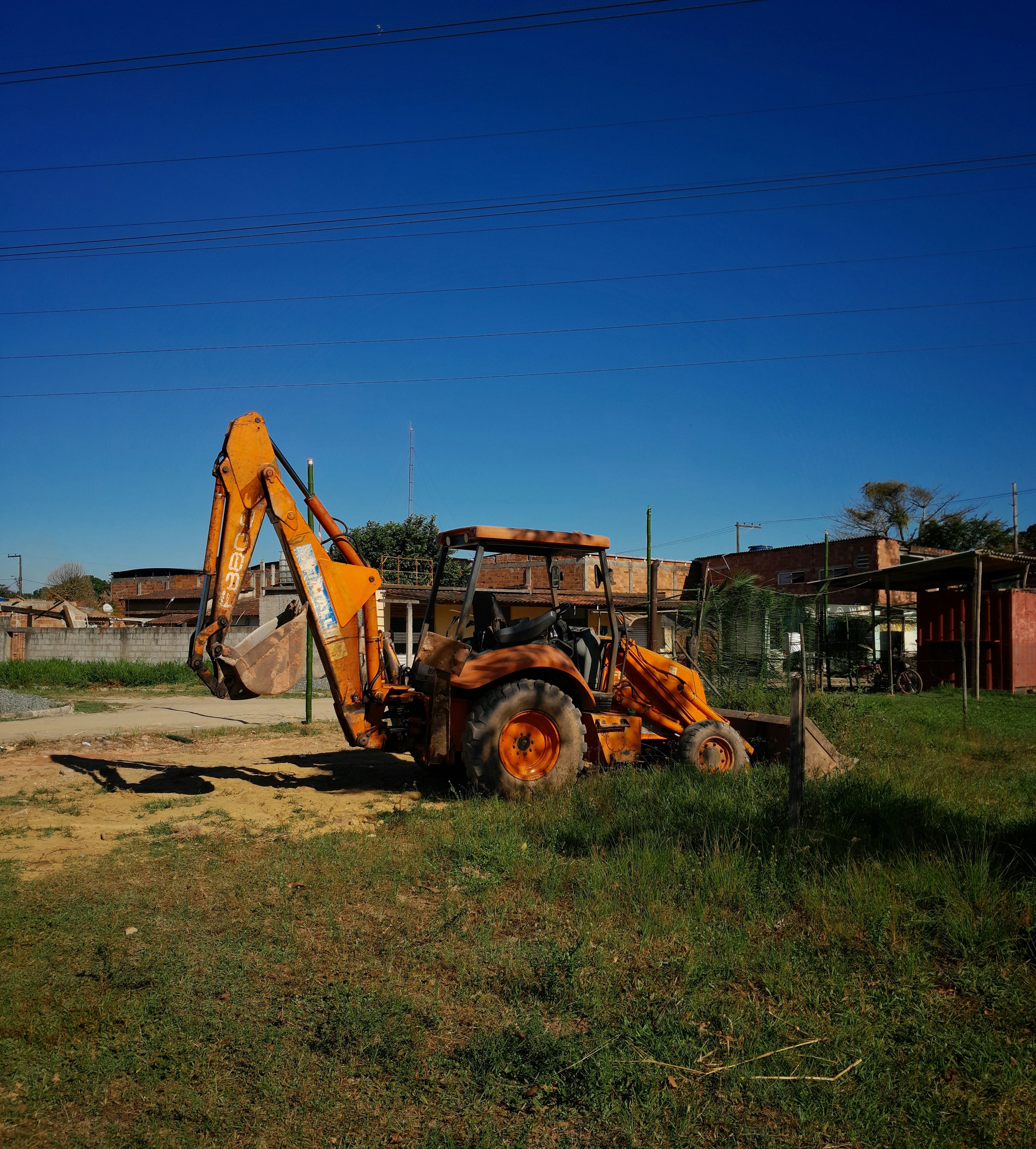 A tractor is parked in a field with a building in the background