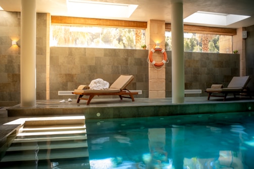 A large swimming pool with a lounge chair next to it
