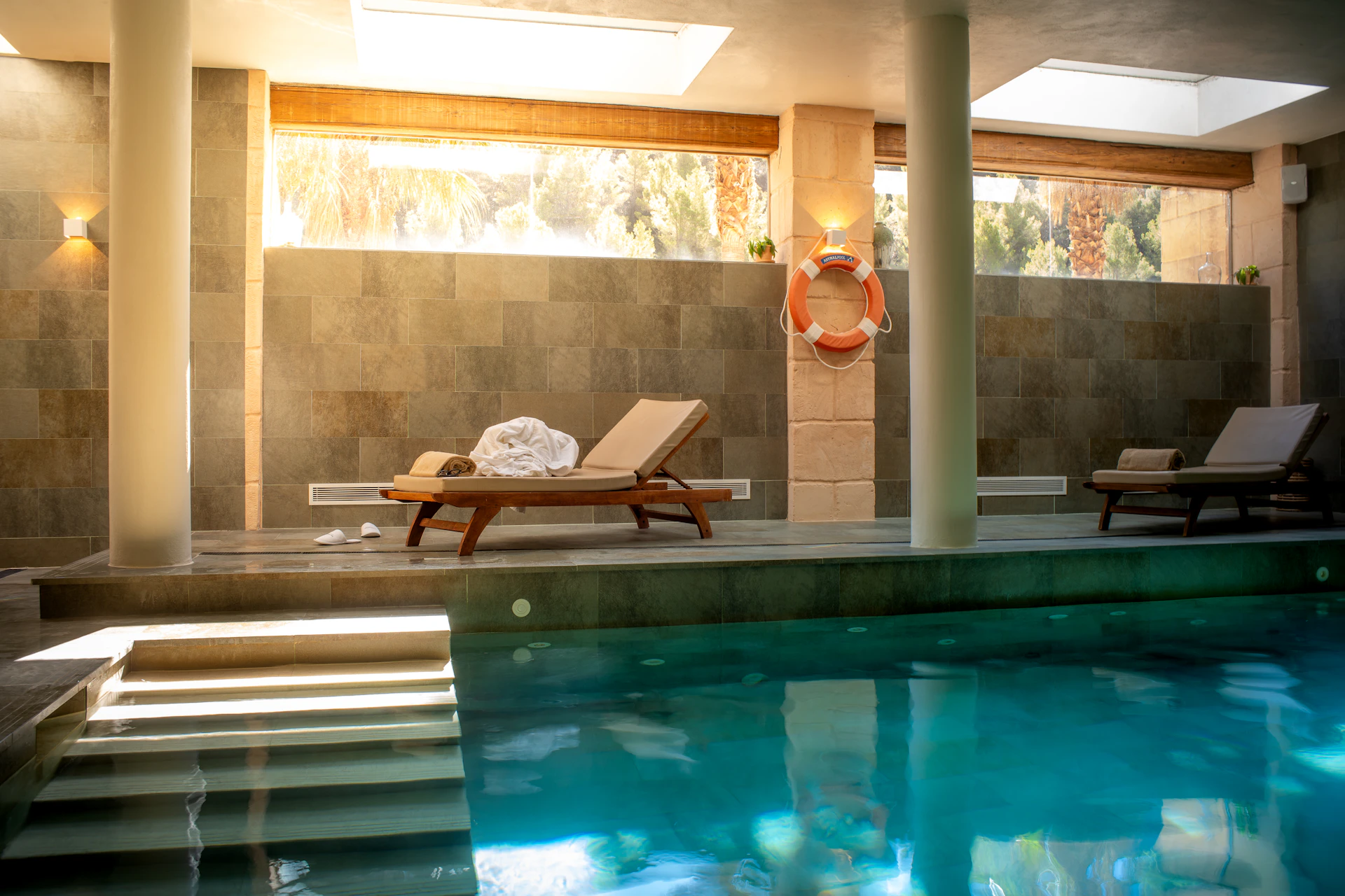 A large swimming pool with a lounge chair next to it
