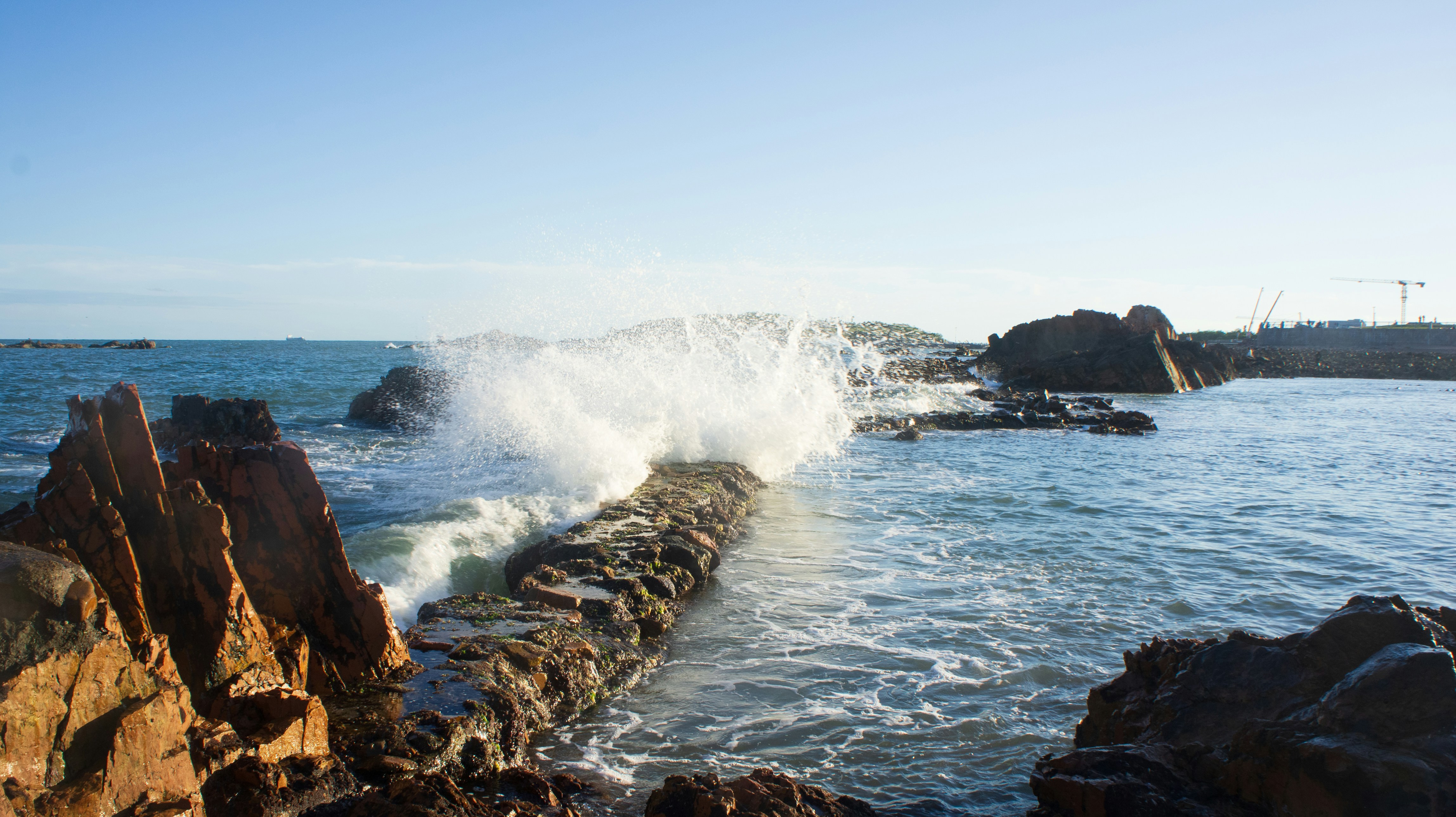 Eine Welle schlägt gegen die Felsen am Strand