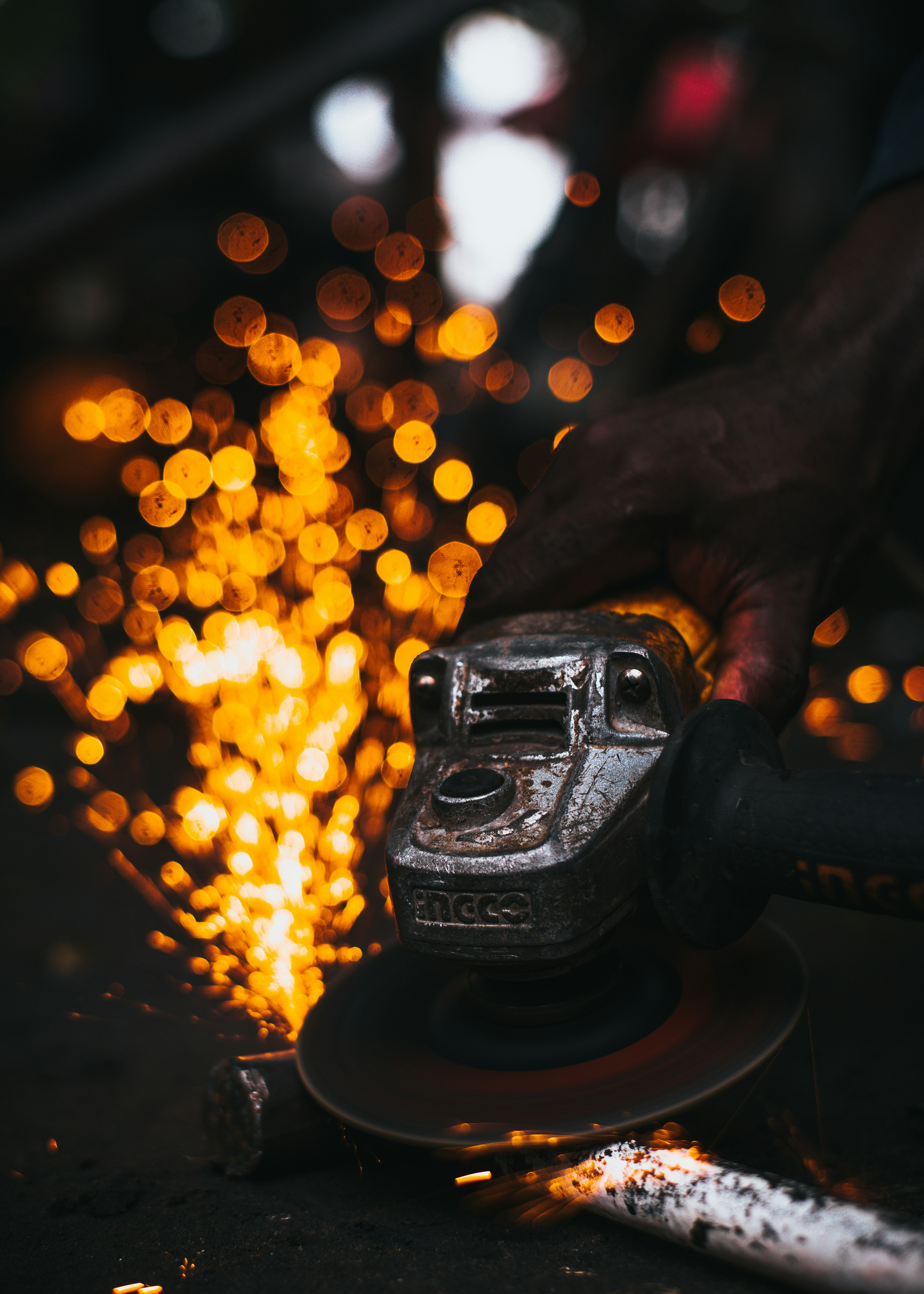 A person grinding a piece of metal with a grinder
