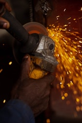 A person using a grinder on a piece of metal