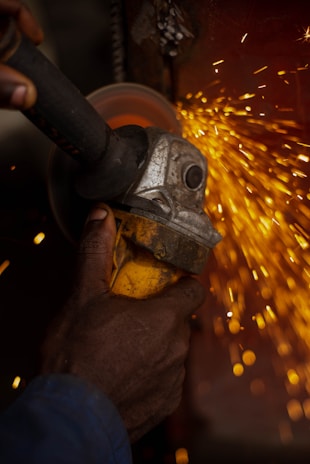 A person using a grinder on a piece of metal