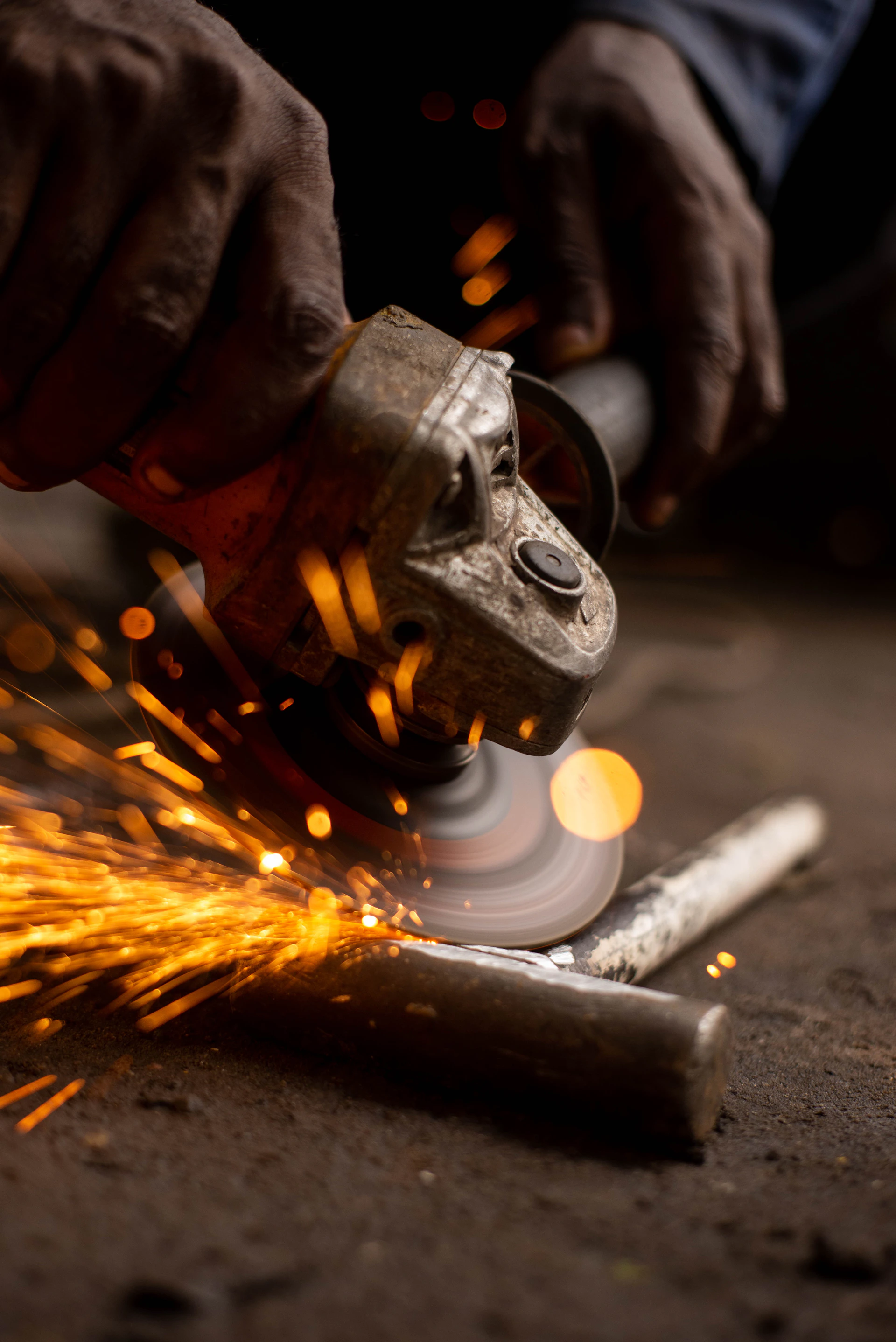 A person using a grinder on a piece of metal