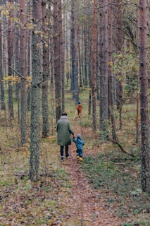 A man and a child walking through a forest