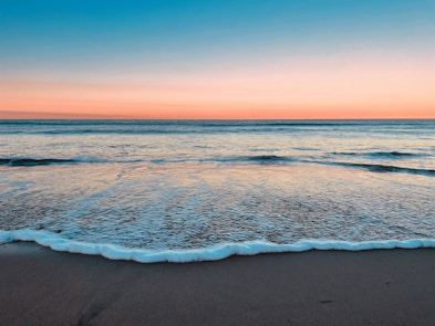 A sandy beach with waves coming in to shore