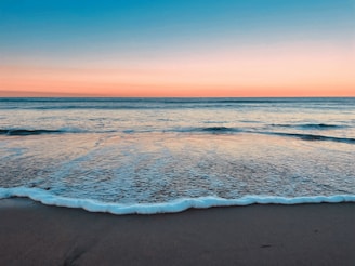 A sandy beach with waves coming in to shore