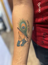 A person with a peacock tattoo on their arm