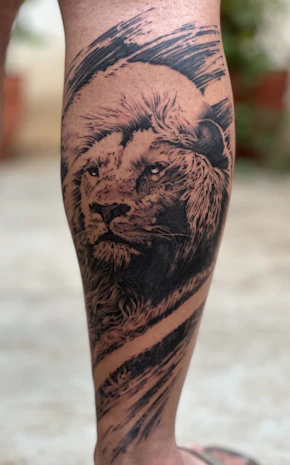 A man with a lion tattoo on his leg