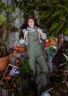 A woman standing in a garden surrounded by potted plants