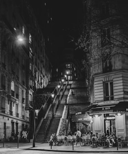 A black and white photo of a city street at night