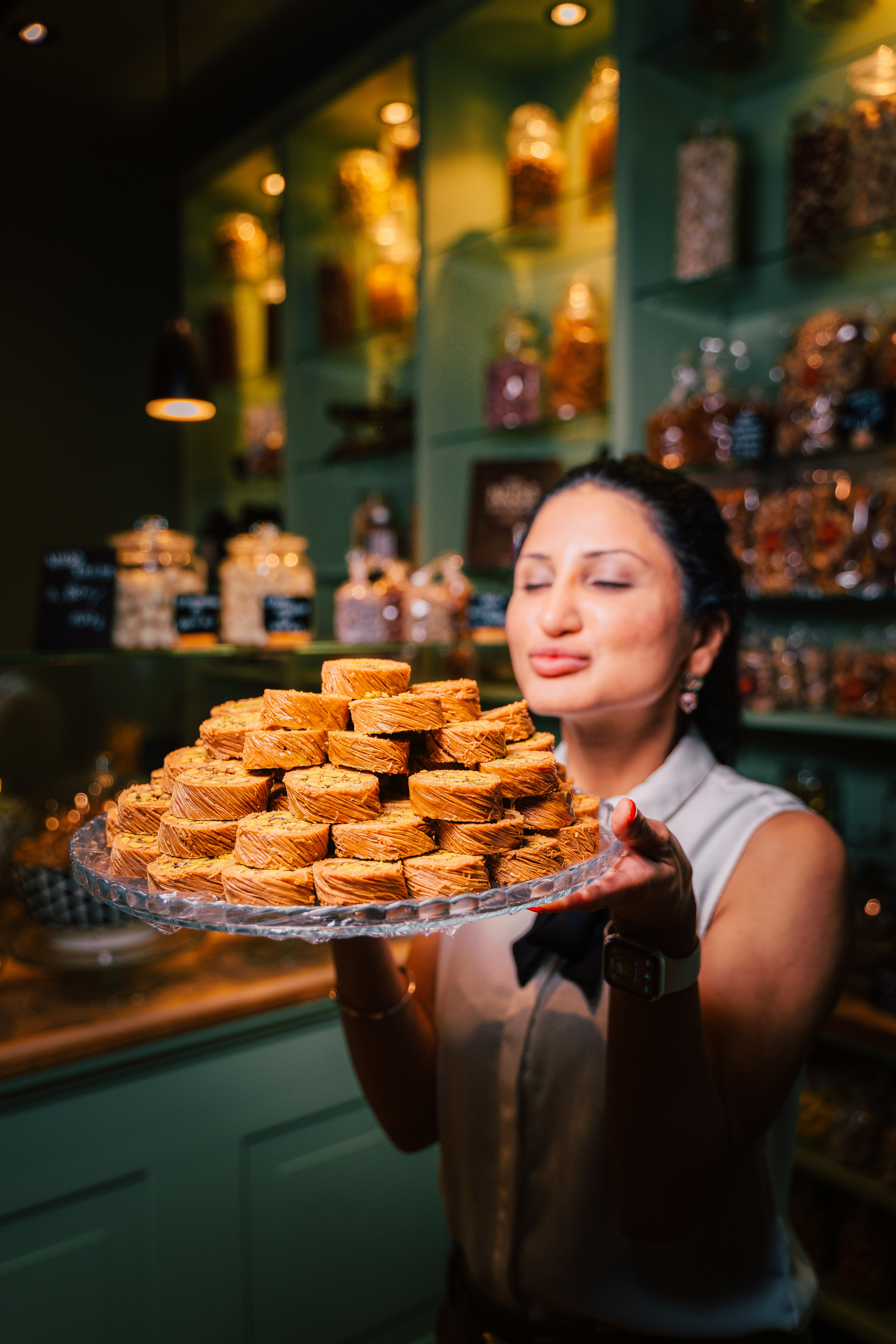 A woman holding a tray of donuts in a store