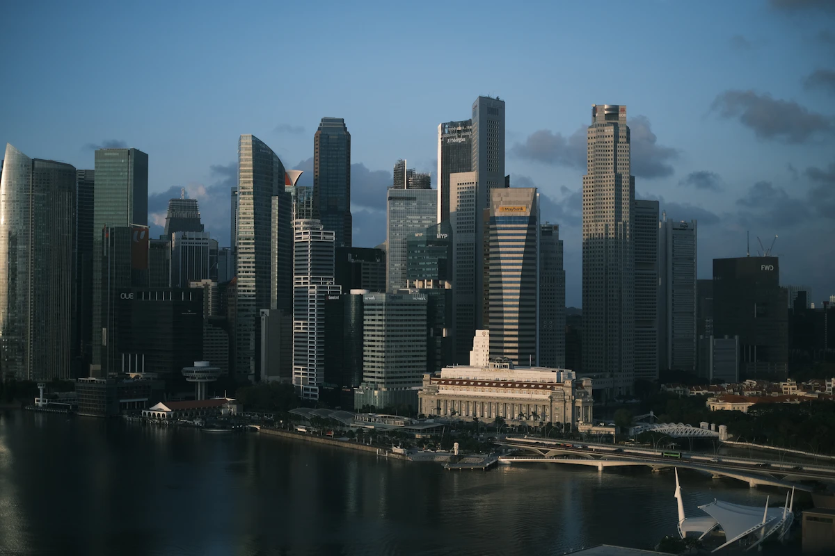 Night skyline of Singapore with illuminated skyscrapers reflecting across the Singapore River