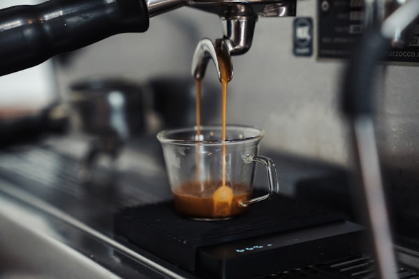 Espresso being poured into a glass cup