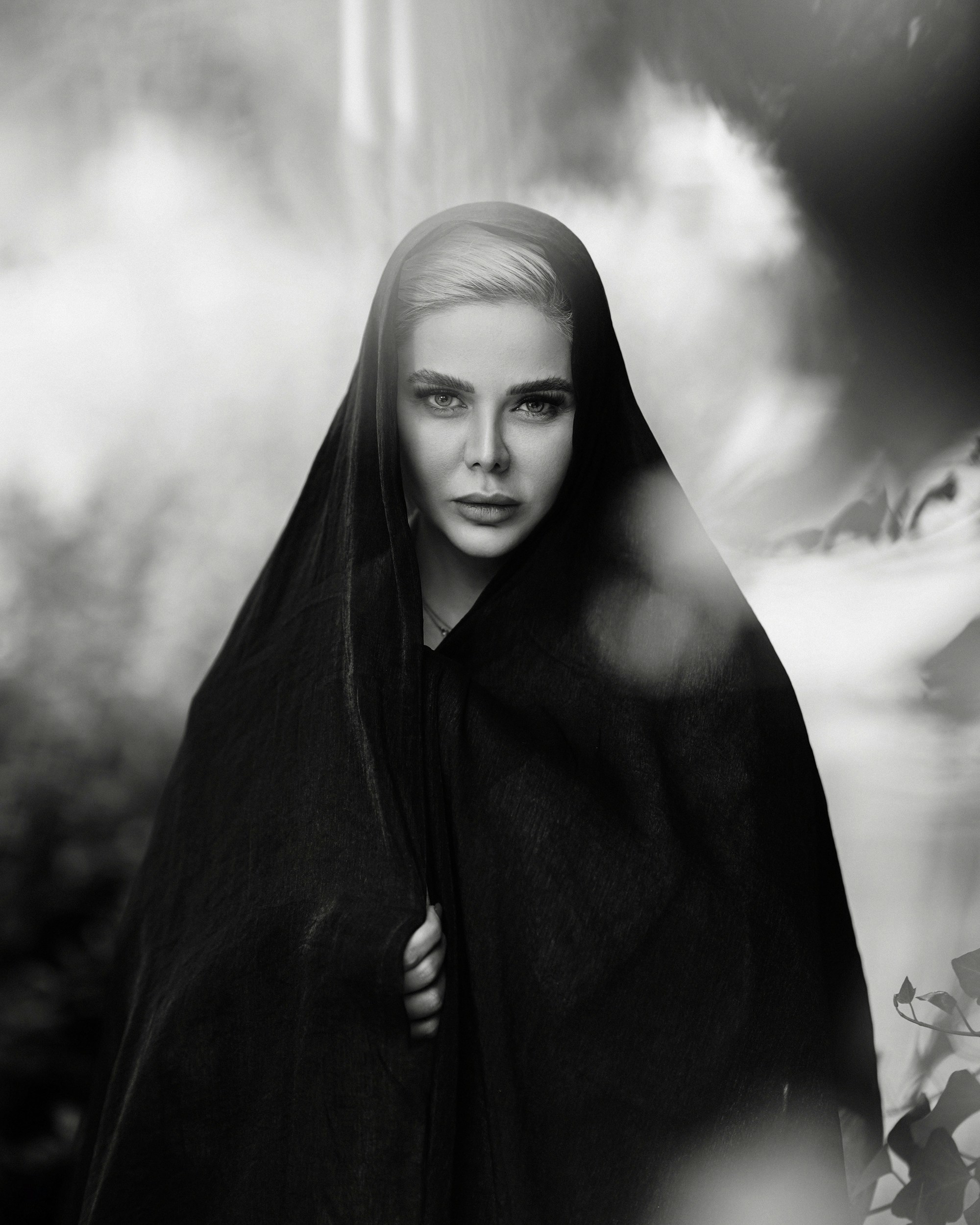 A black and white photo of a woman wrapped in a blanket
