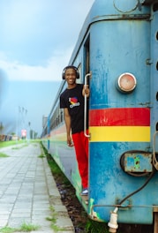 A boy standing on the side of a train
