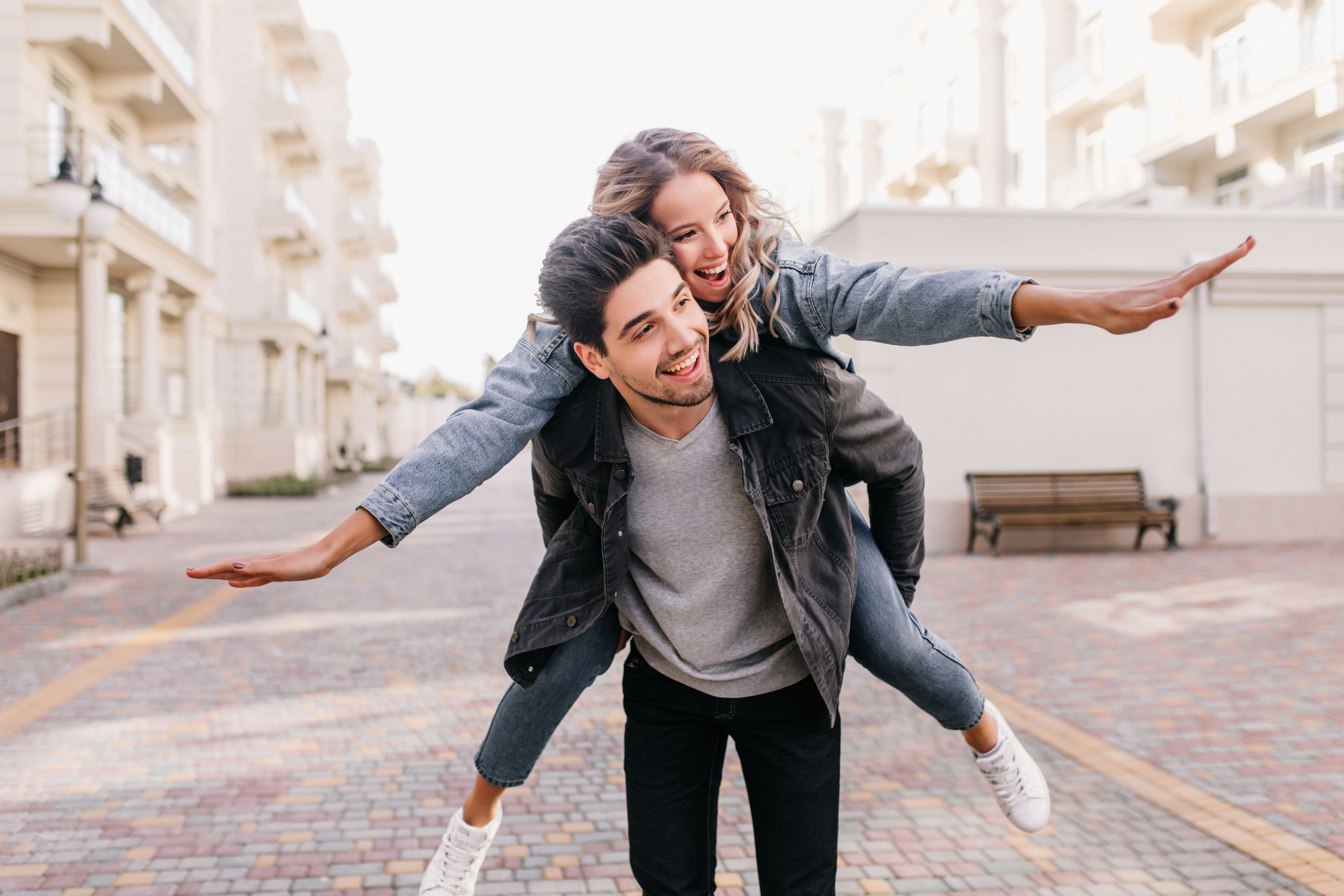 A man riding on the back of a woman on a skateboard