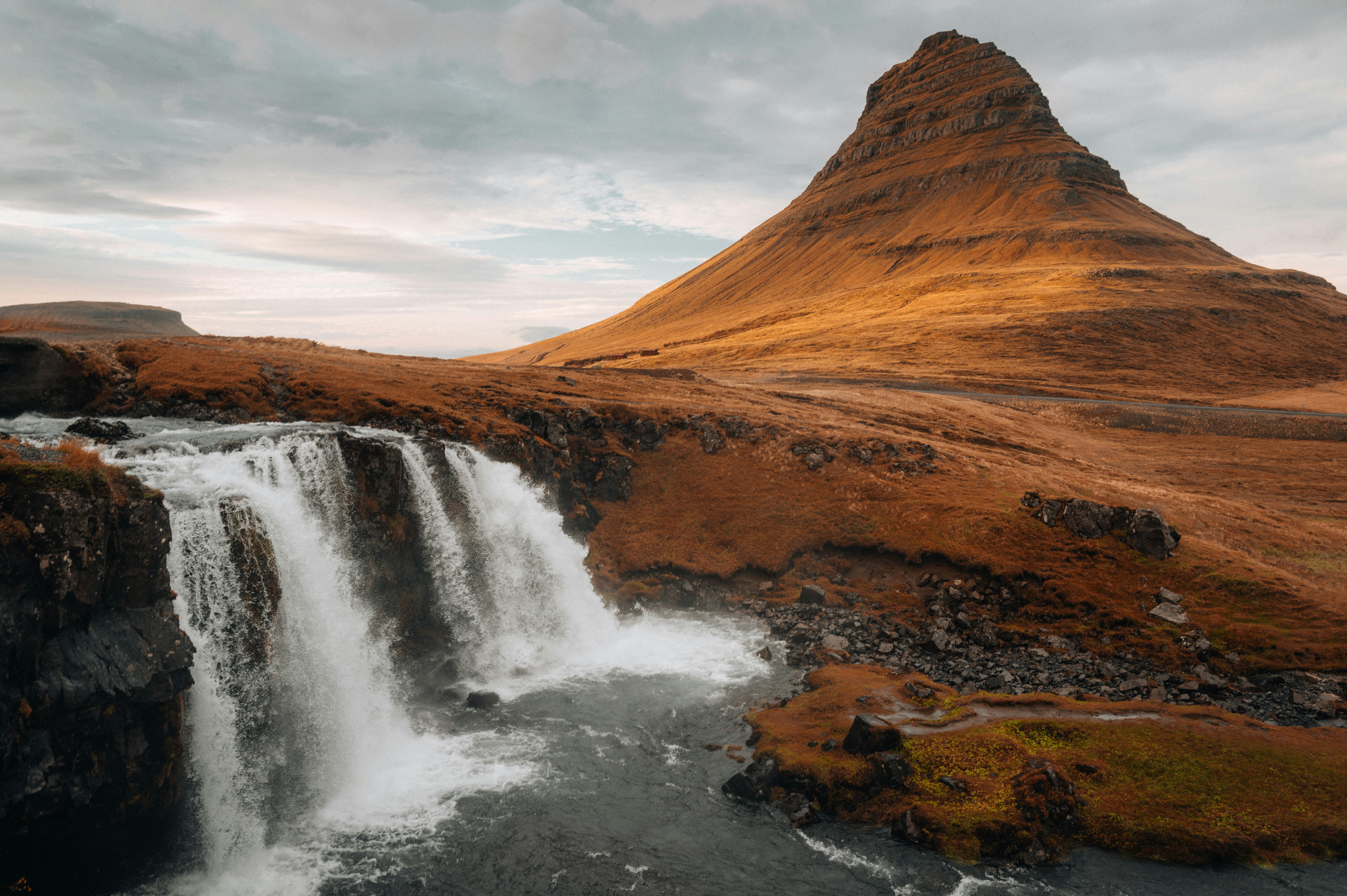 A waterfall with a mountain in the background