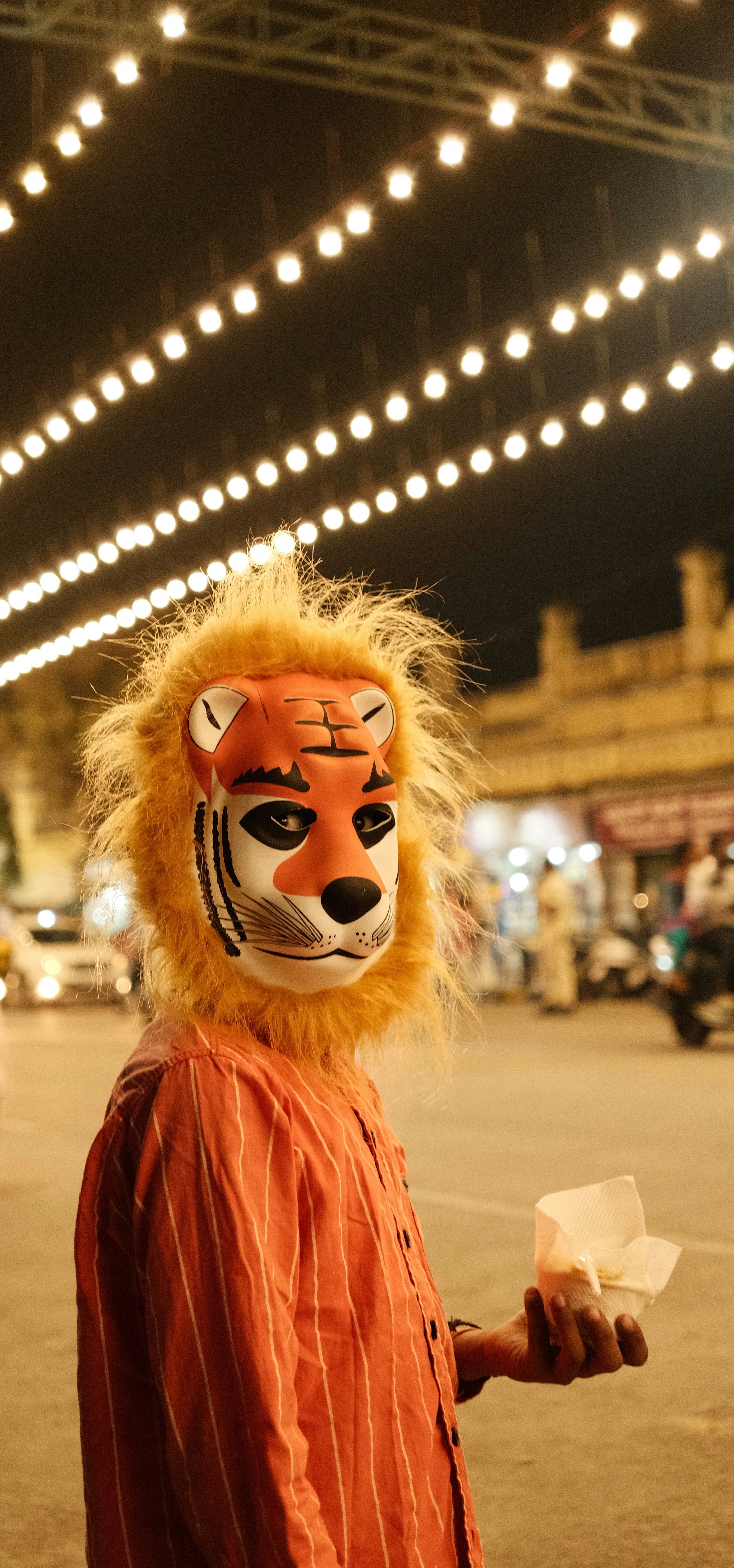 A man in a lion mask holding a piece of paper