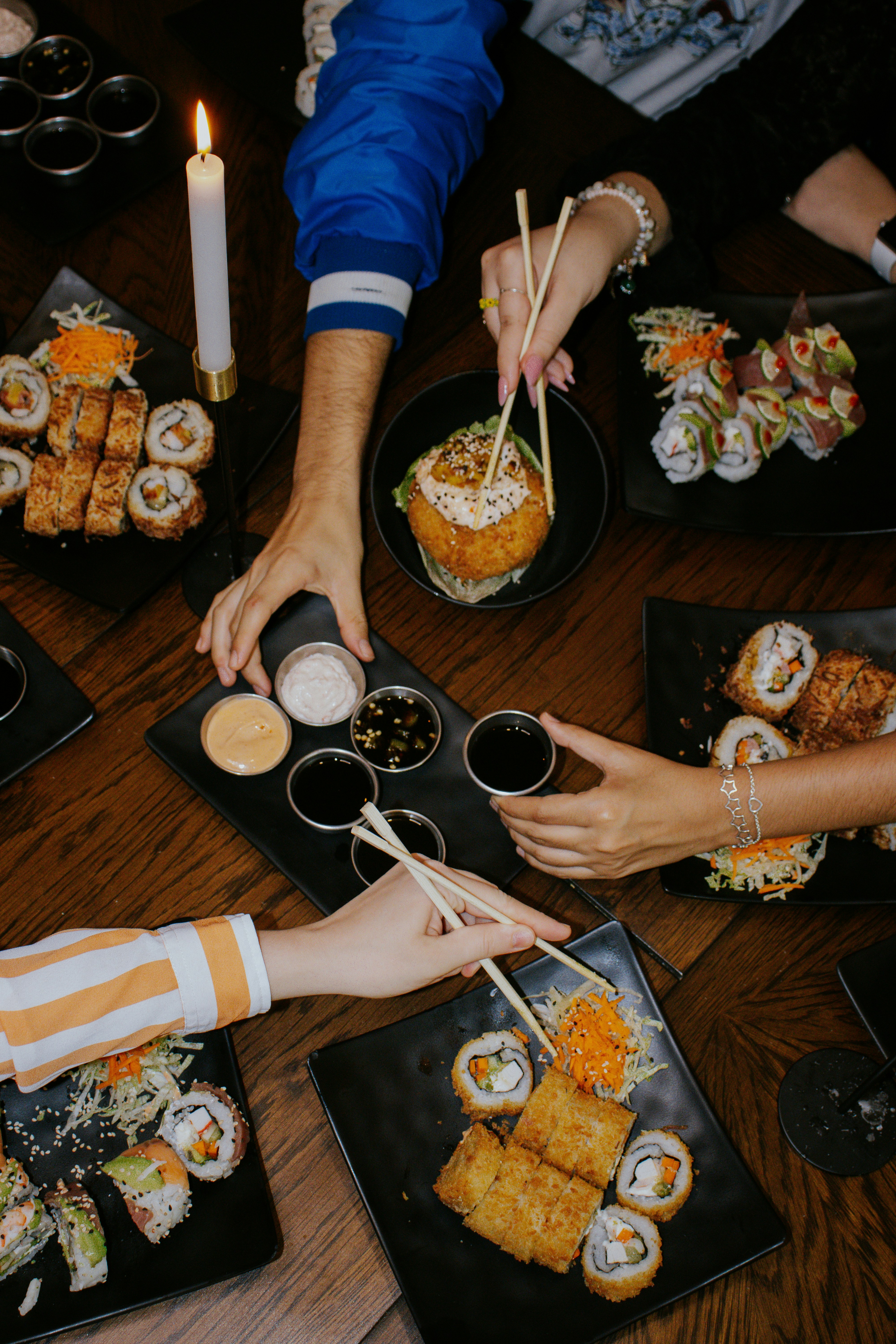 Un groupe de personnes assises autour d’une table mangeant des sushis