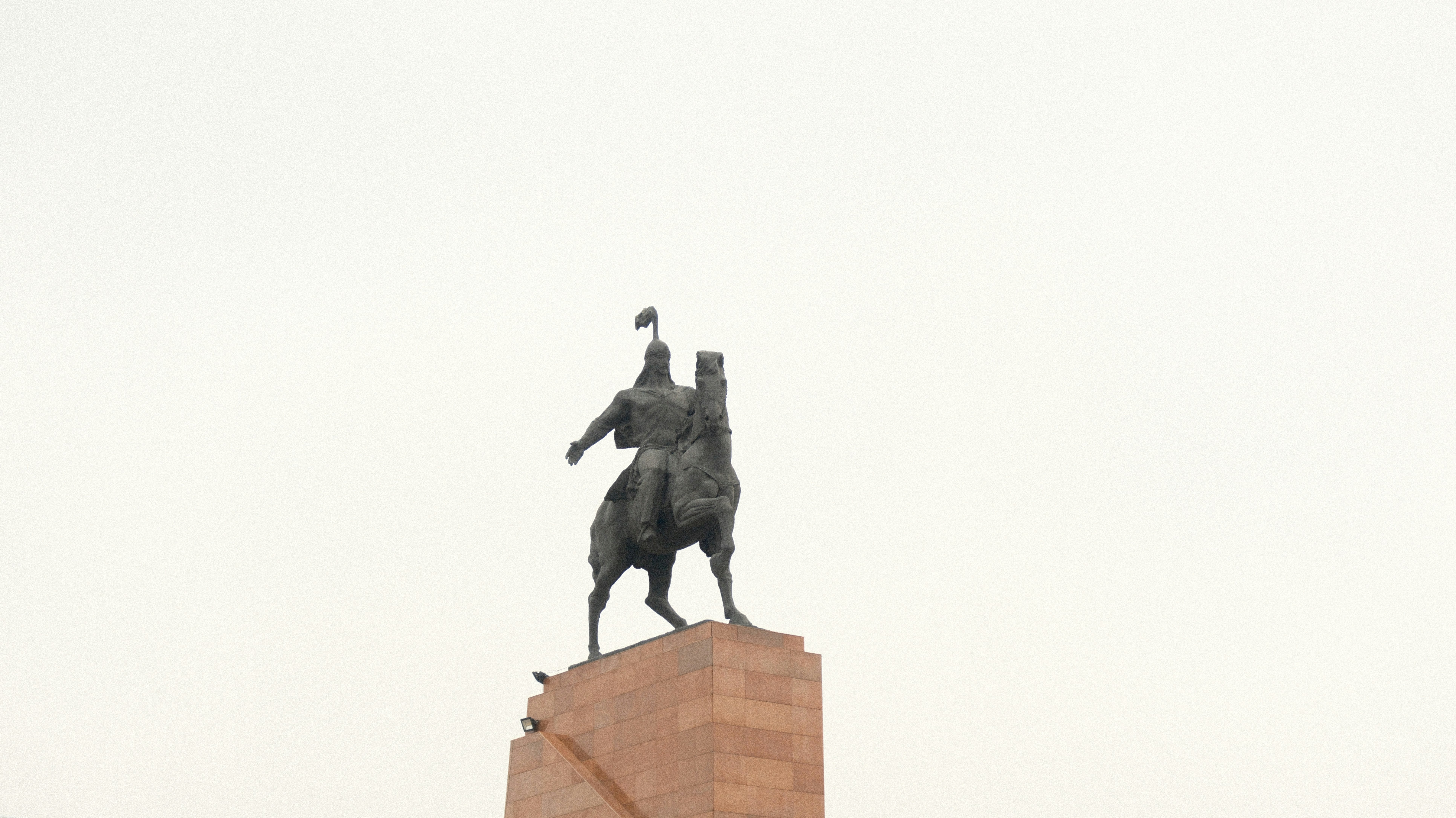 A statue of a man on a horse on top of a building