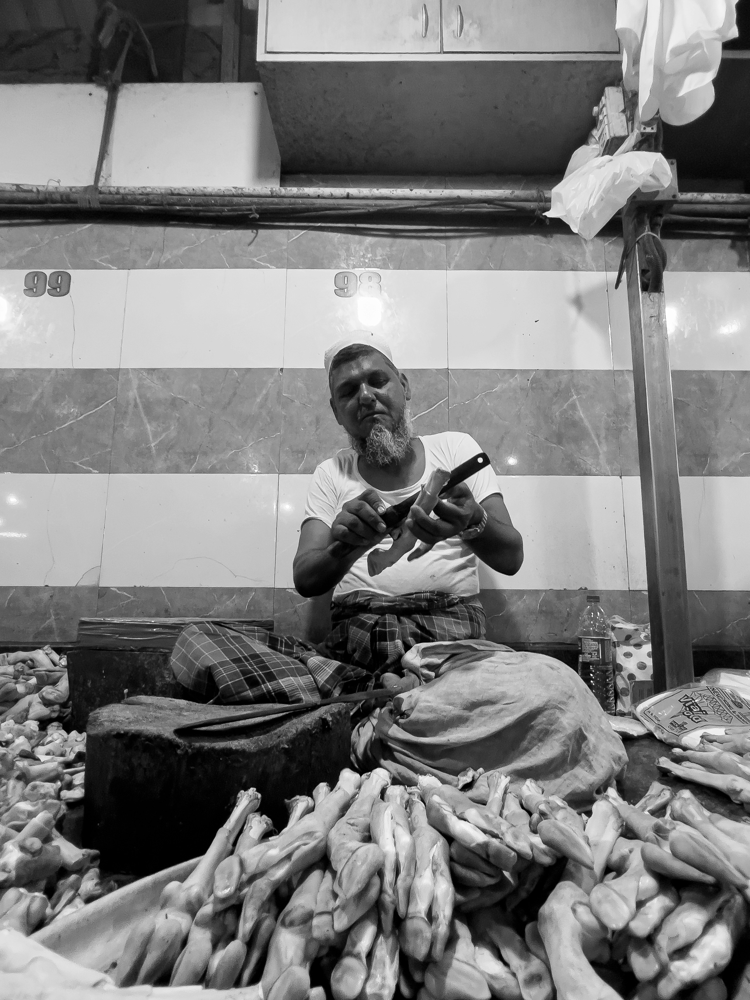 Butcher sharpening knife at traditional market stall, warm African market atmosphere