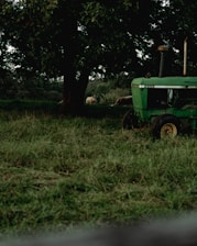 A green tractor is parked in a field