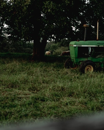 A green tractor is parked in a field