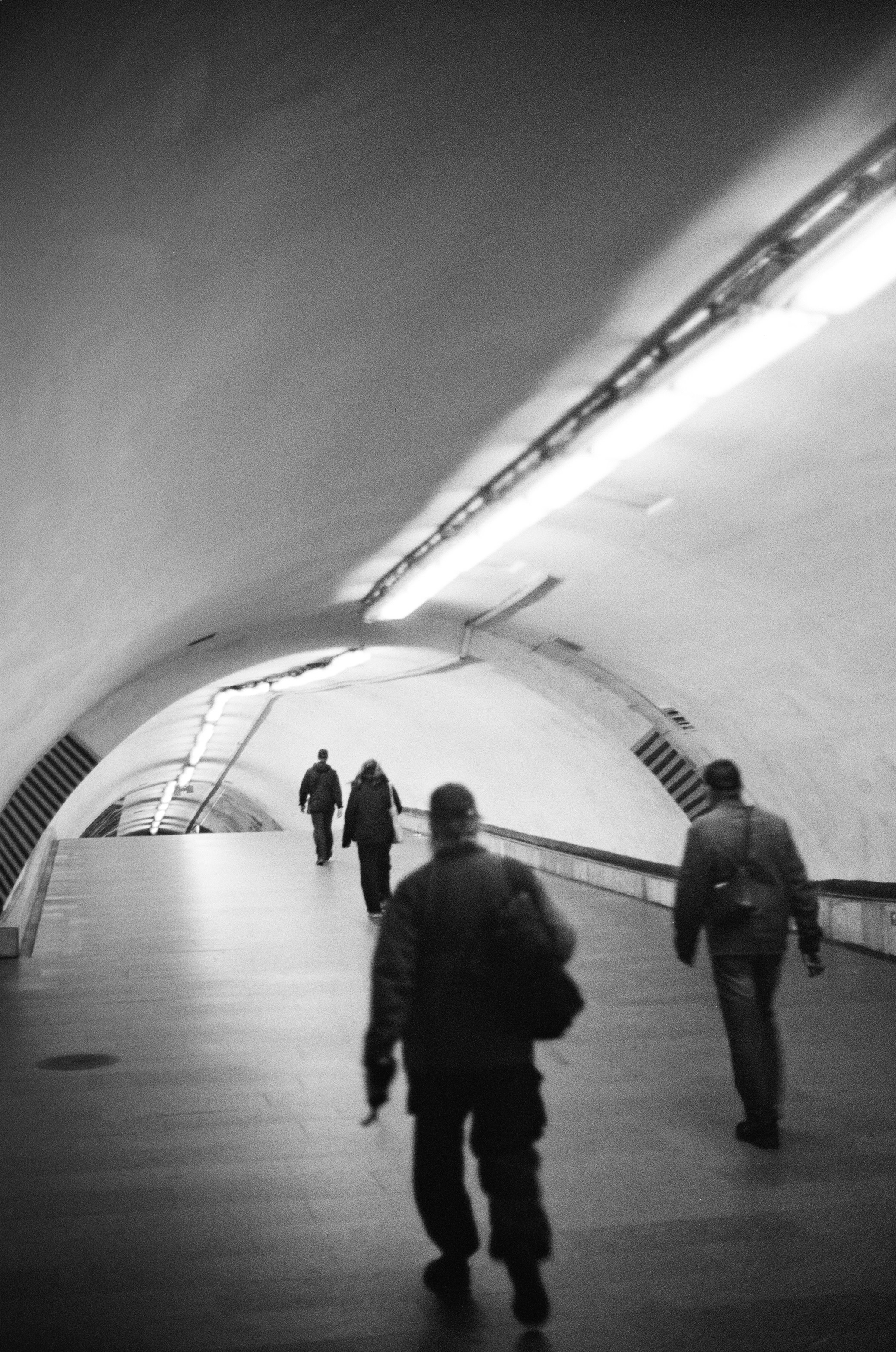 A black and white photo of people walking in a subway