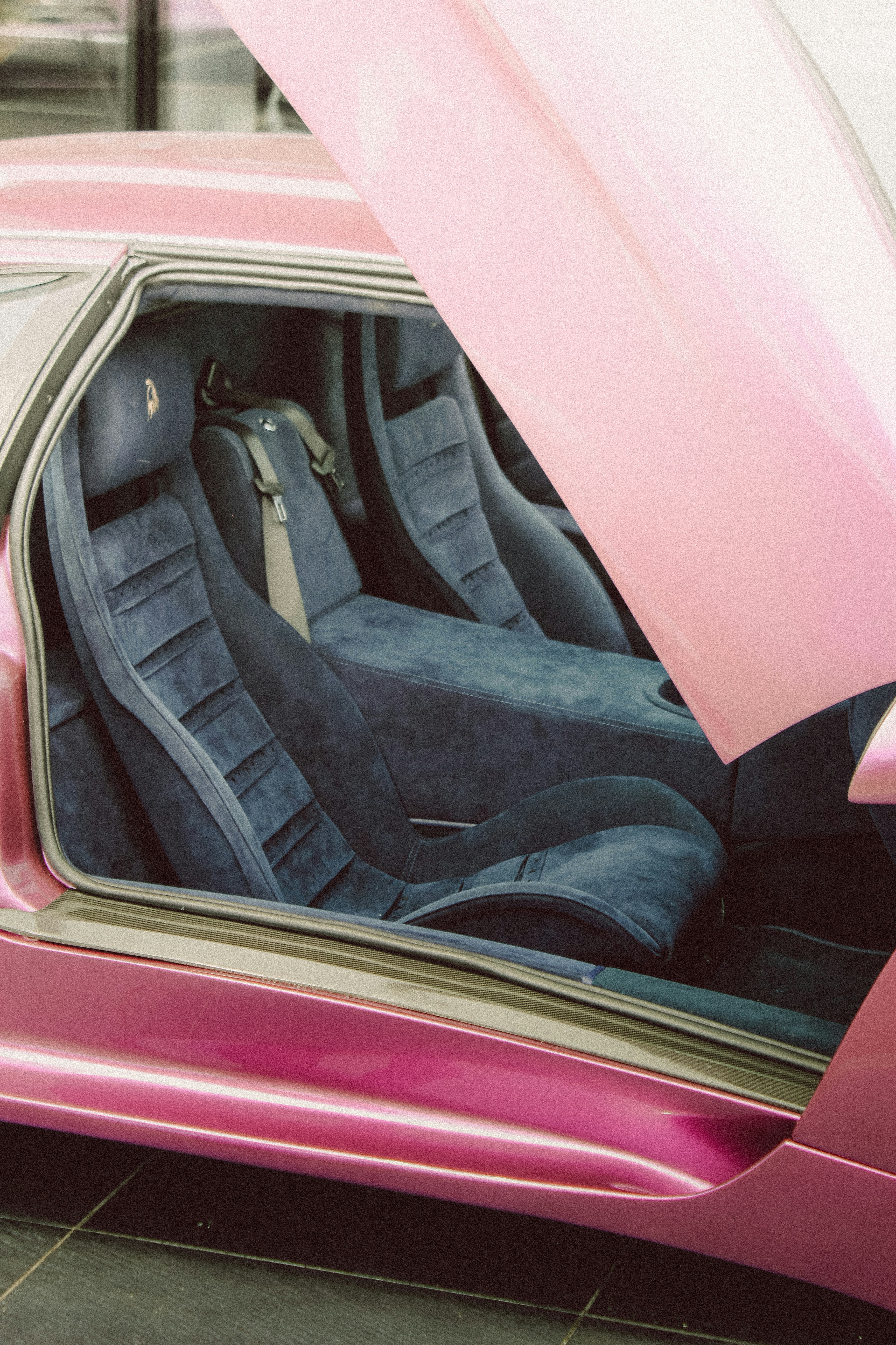 Um carro cor-de-rosa com a porta aberta mostrando o interior