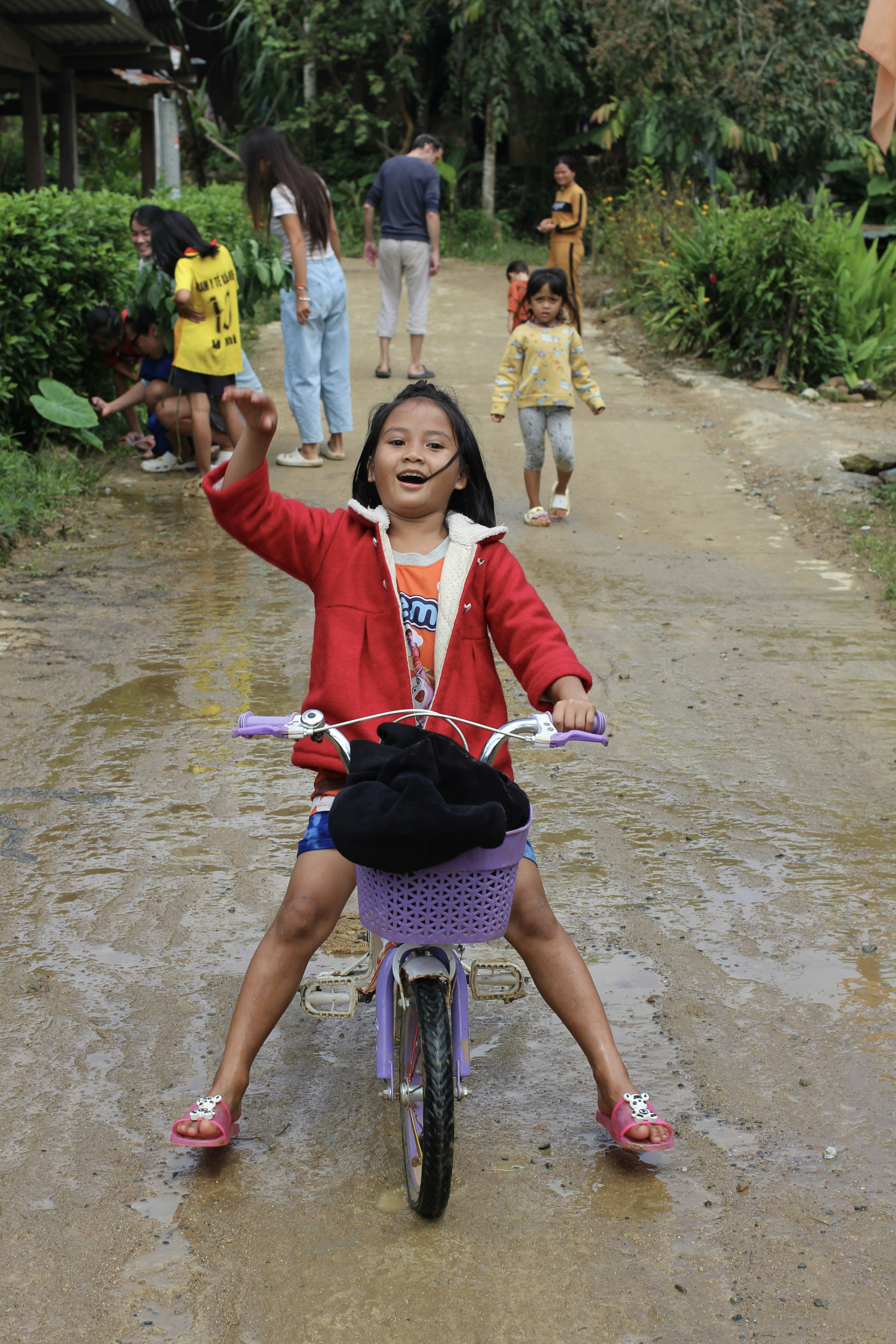 A little girl riding a bike down a dirt road