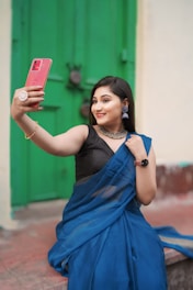A woman in a blue sari taking a selfie