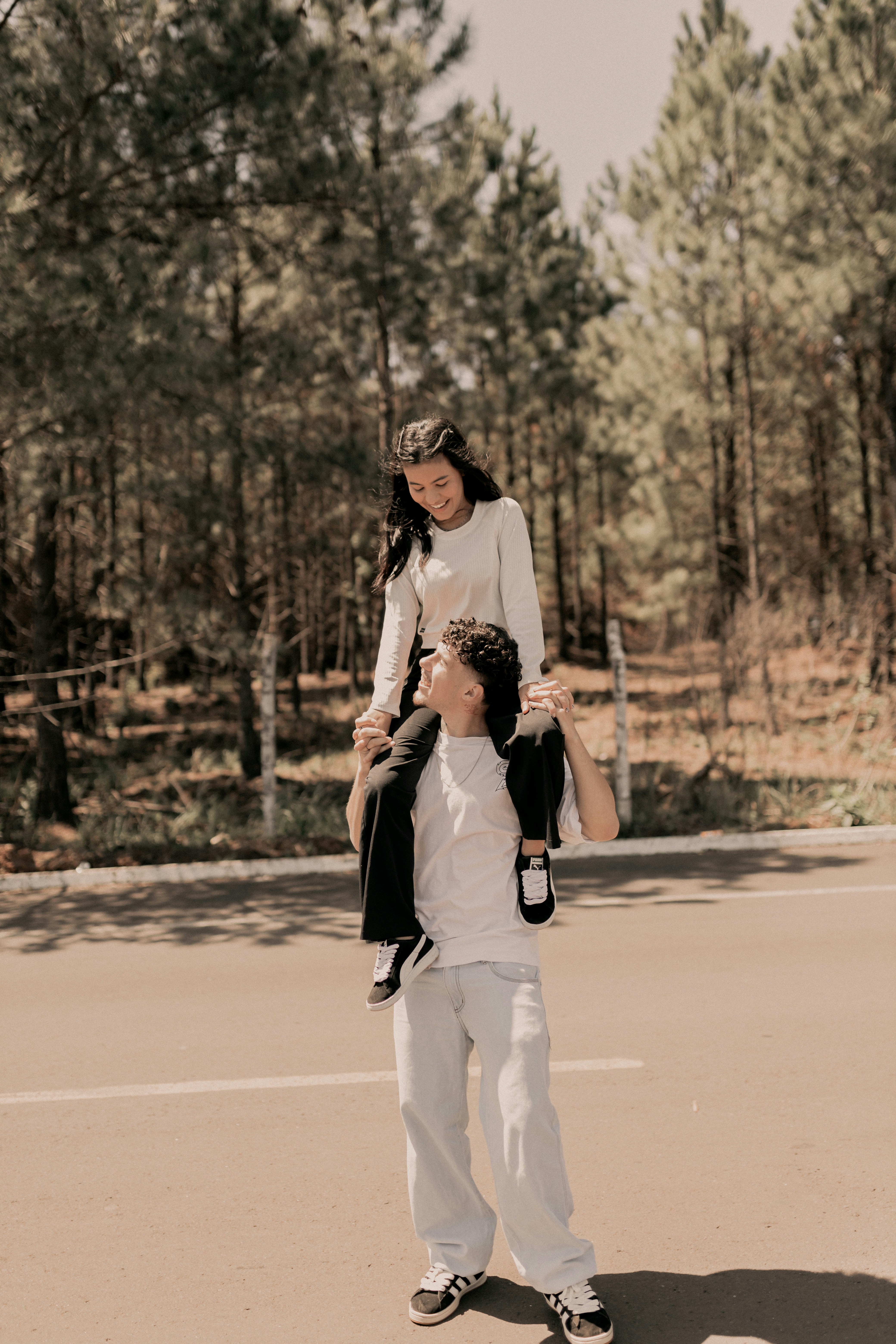 Seorang pria mengendarai punggung seorang wanita di atas skateboard