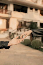 A man in a leather jacket is giving another man a hand