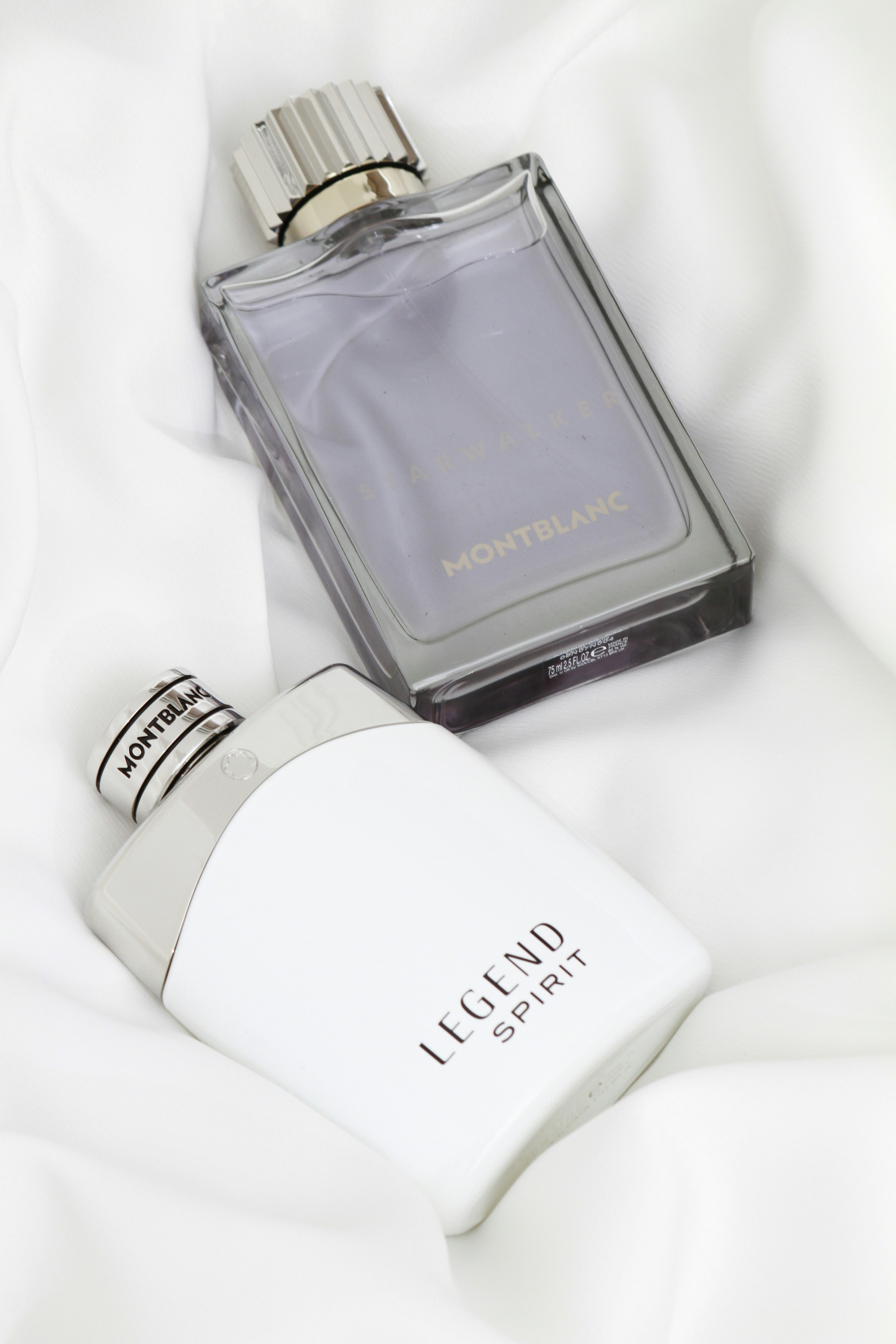 A bottle of perfume sitting on a white sheet