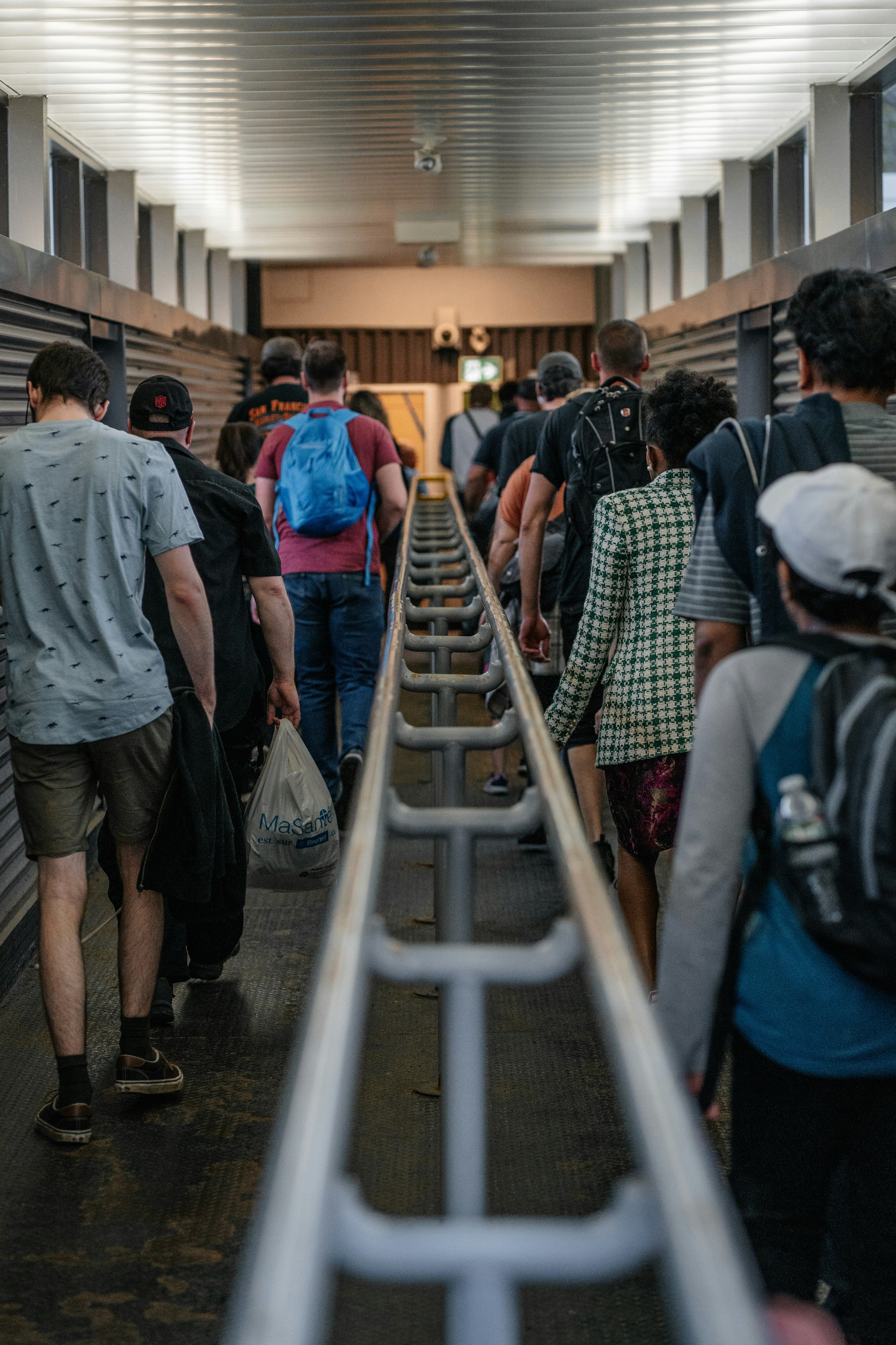 A group of people walking down a long hallway