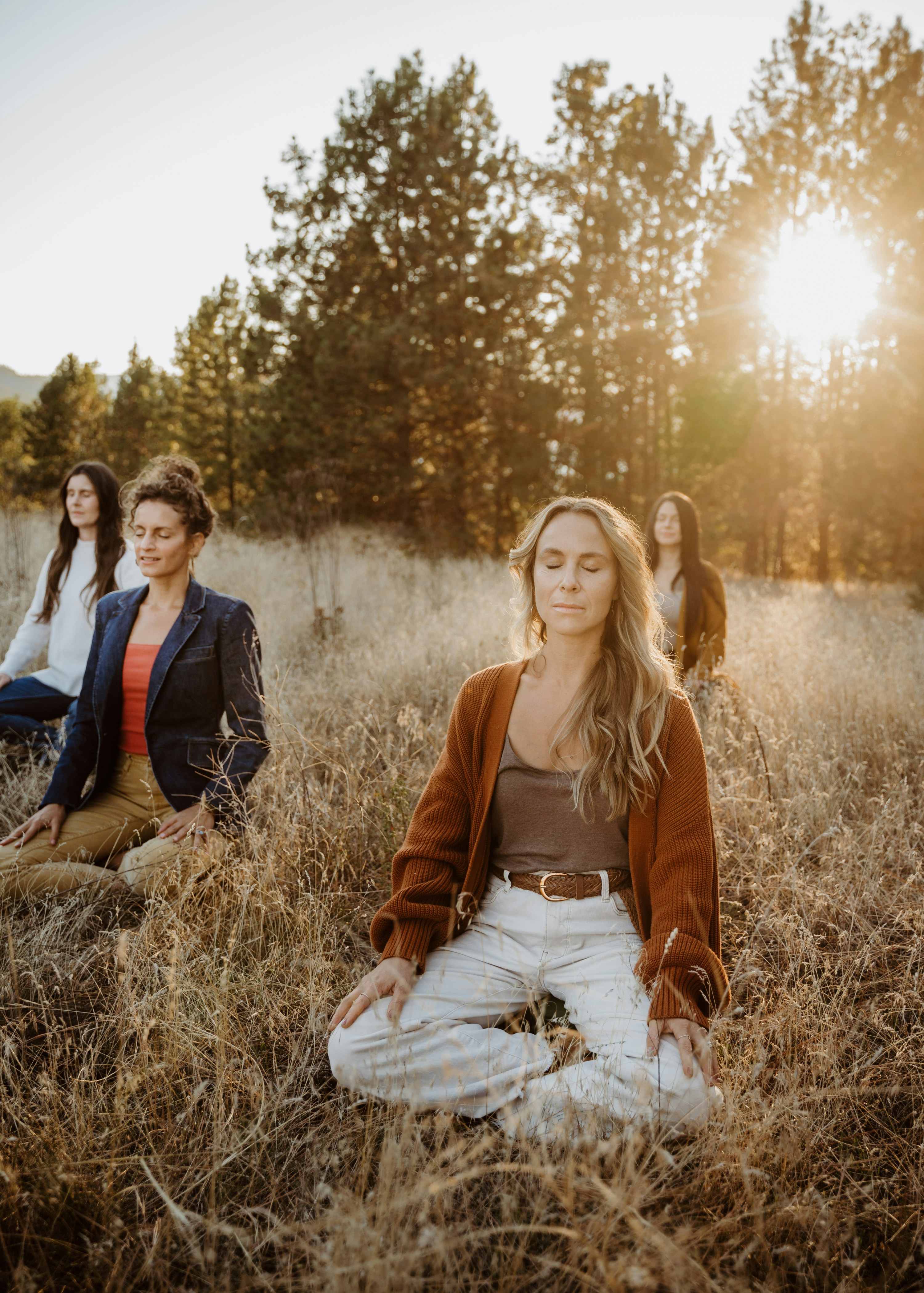 A group of women sitting on top of a grass covered field