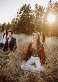 A group of women sitting on top of a grass covered field