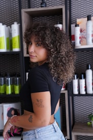A woman standing in front of a shelf of hair products