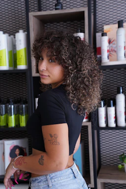A woman standing in front of a shelf of hair products